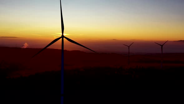 Silhouettes of Wind Turbines Spinning in Front of Scenic Sunset Sunlight, Aerial View. Alternative E