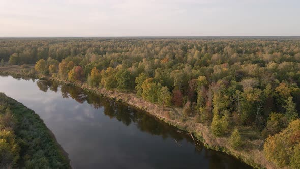 High Flight Over the Calm Water of a Wide River at Sunset