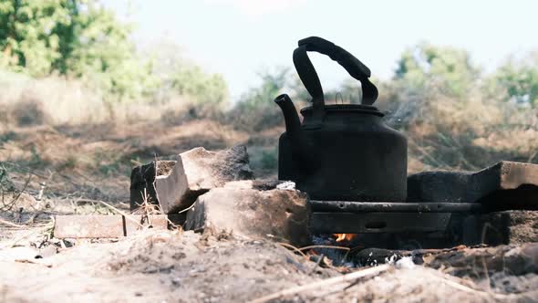 Tourist Kettle Standing on a SelfMade Campfire Stove in Tourist Camp in Nature