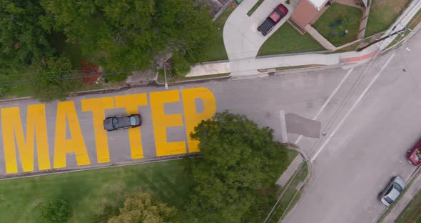 Bird eye view of a large "Black Towns Matter" sign painted on street in Houston Historical independe