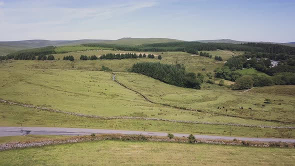 AERIAL VIDEO looking into distance over moorland and small road