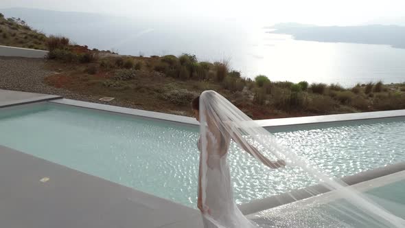 Aerial view of woman with wedding dress in Santorini island, Greece.