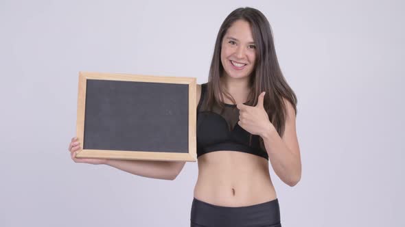 Young Happy Woman Holding Blackboard and Giving Thumbs Up Ready for Gym