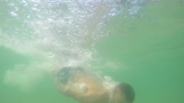 Young Man Diving Swimming Underwater.