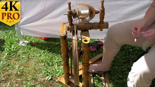 A Man is Pedalling the Spinning Wheel