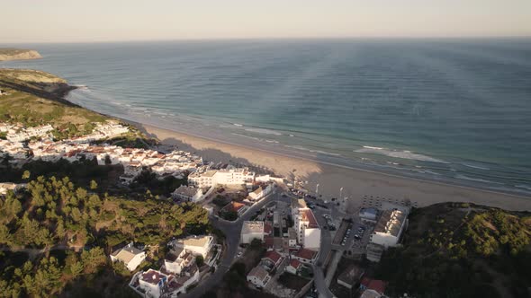 Salema coastal village, Algarve. Panoramic view of beach and sea. Aerial pullback