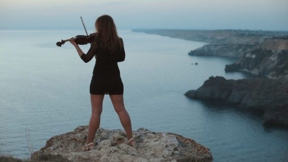 Young Girl In Short Dress Standing On a Cliff