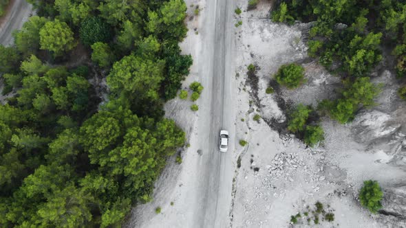 Aerial landscape. Fly over mountain road with car. Lateral top view