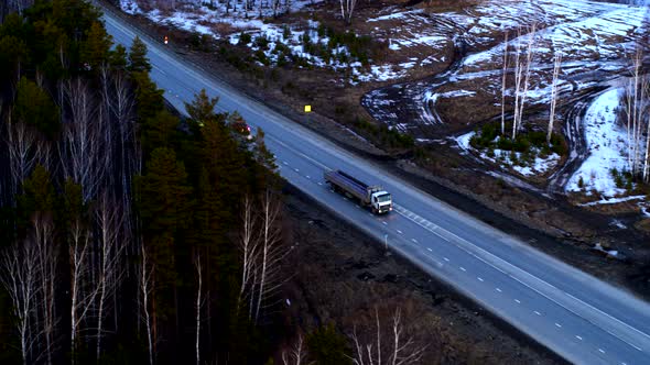 Aerial View of The Truck that Rides on A Huge Interchange at Sunset