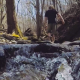 Hiker Walking in Nature through Stream - VideoHive Item for Sale