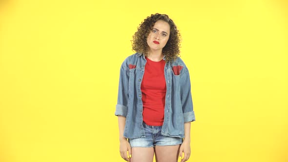 Woman Looking at Camera with Anticipation, Then Very Upset on Yellow Background at Studio.