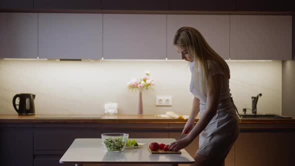 Woman Cuts Ripe Red Tomato to Make Tasty Salad at Table