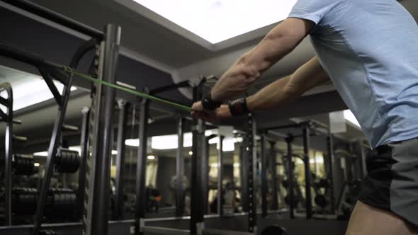 Close up image of man doing exercise with elastic band at the gym.