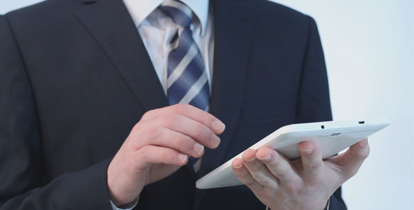 Man in a Suit Uses a Tablet