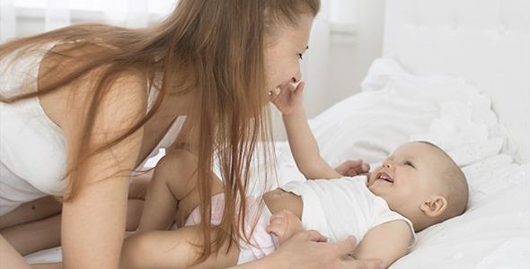 Happy Mother Playing With Her Baby on Bed 11 alt