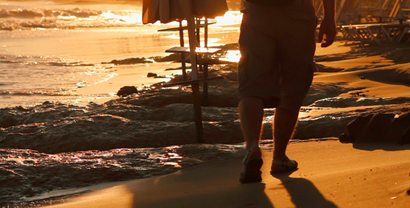 A Man Walking on the Beach at Sunset 1