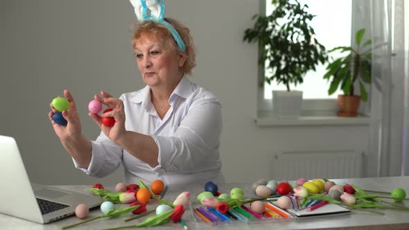 Elderly Woman Pains Easter Egg Yellow Colour