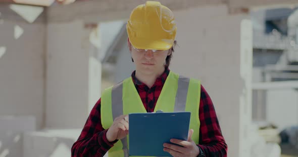 Confident Young Male Contractor Holding Clipboard