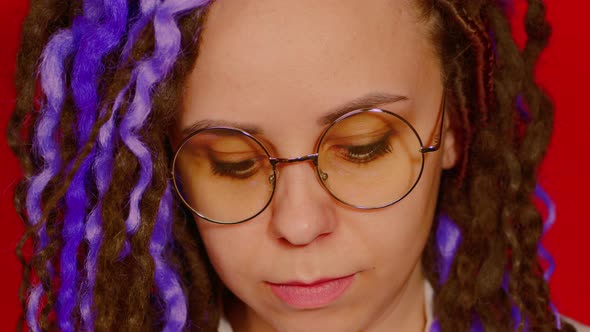 Portrait of Young Woman in Glasses with Brown Purple Dreadlocks