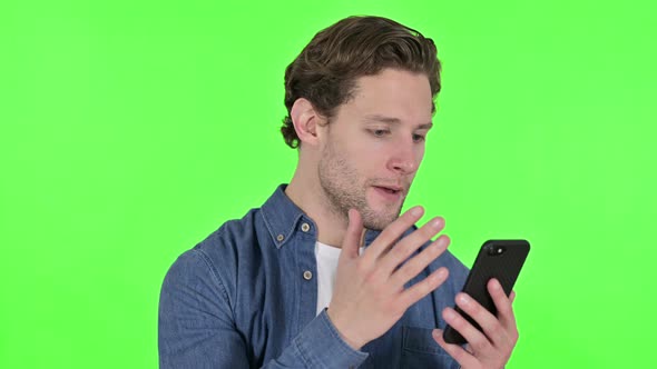 Failure on Young Man with Loss on Smartphone on Green Chroma Key