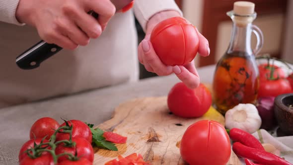 Woman Peels a Tomato Peel By Knife at Domestic Kitchen