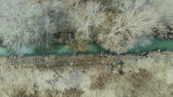 Aerial top view of narrow dirty river. Polluted river full of dirty water. Environmental problems