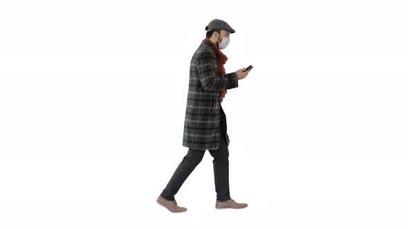 Adult Man Wears Protective Medical Mask Talking on the Phone and Walking on White Background