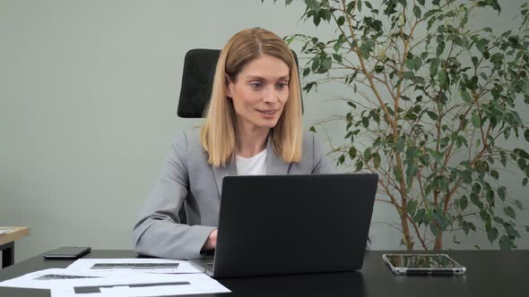 Female Manager Typing on Laptop Keyboard Indoors