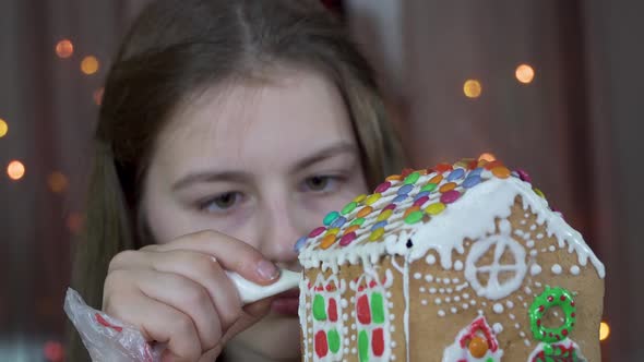 Girl Decorates a Christmas Gingerbread House