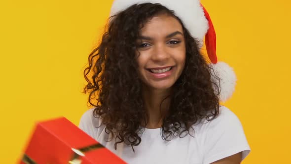 Cheerful Brunette in Santa Hat Dancing With Present, Big Sale Before Christmas