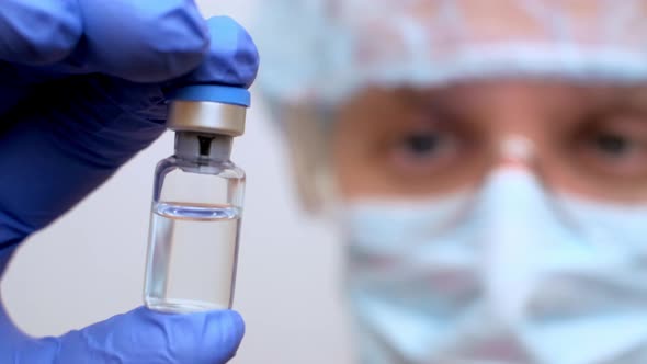 Doctor Looking at Vaccine Ampoule