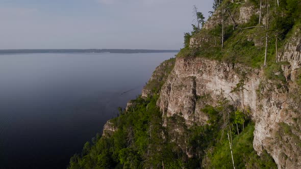 Flight Along a Picturesque Cliff Above the River. A Huge Reservoir and a Steep Stone Cliff