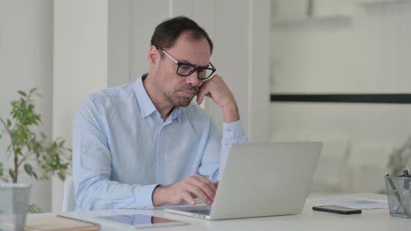 Middle Aged Man Falling Asleep While Using Laptop in Office Nap