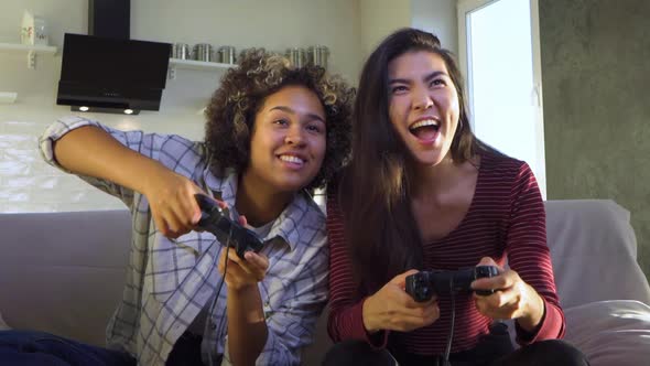 Two Girlfriends Play with Joysticks