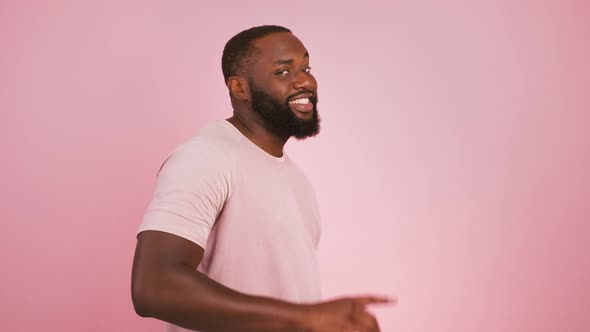 Profile Portrait of Black Man Turning to Camera and Indicating Happily at Camera Choosing Pink