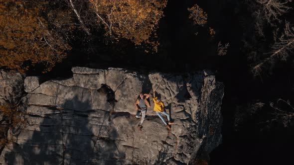 Top Down Drone Selfie Happy Couple Hikers Lying on Top of Cliff