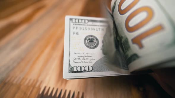 Flipping a stack of one hundred dollar bills extreme close-up shot