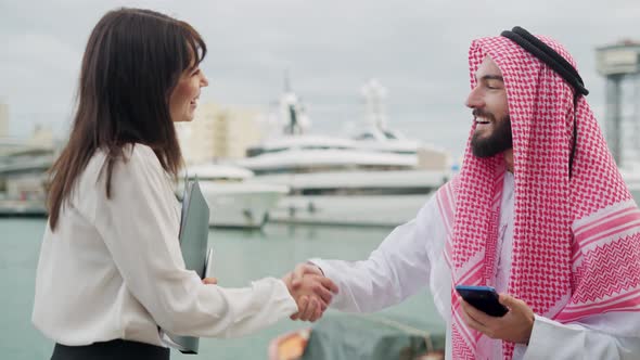 Arab Male Meeting with Female Entrepreneur in Harbor