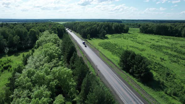 Drone Point of View Shot of White Truck Driving on Highway Road in Forest