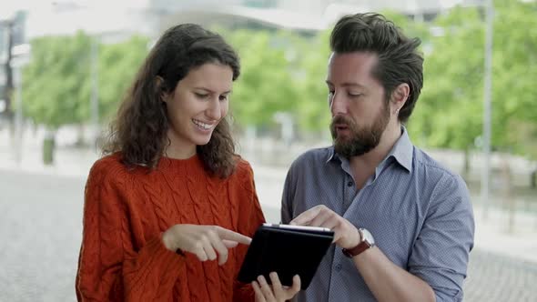 Couple Talking and Using Digital Tablet Together