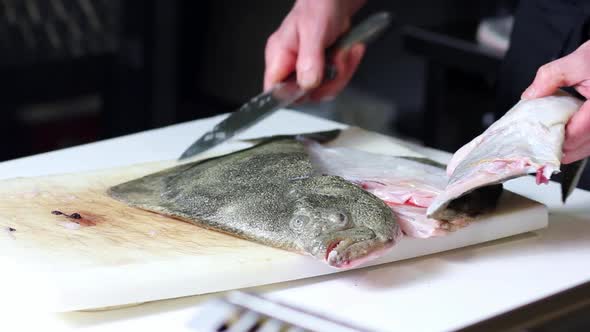 Raw turbot fish getting cleaned up and cut in fillet at a fish a fish vendor establishment