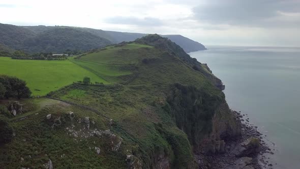 Forward tracking aerial over the coast at The Valley of Rocks, Devon. Looking West much higher than