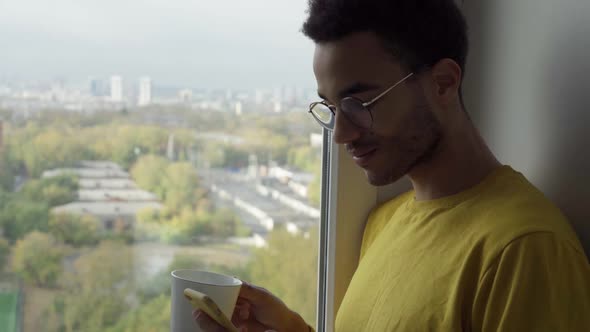 At the Window a Young Man with a Mug