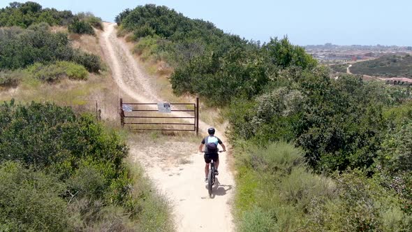 Aerial View of Riding Mountain Bike in a Small Singletrack Dry Trail in the Mountain.