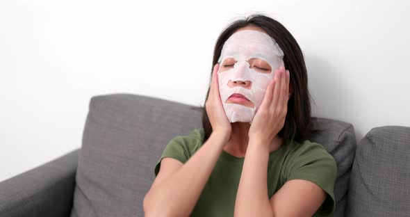 Woman apply skincare mask on face at home