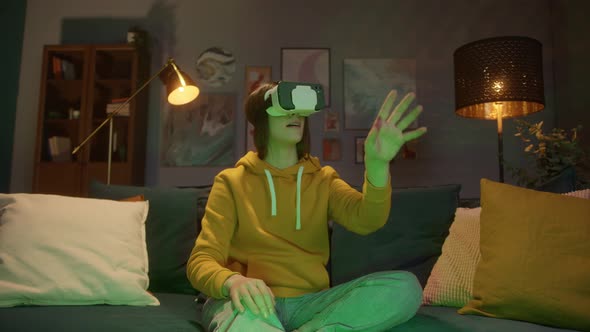 Young Woman in VR Headset Looks Around and Wonders How Amazing