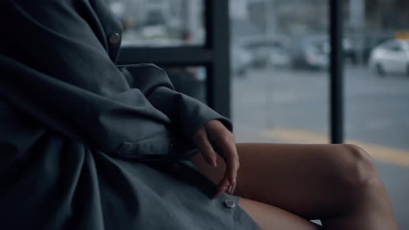 Woman Sitting Bus Station in Urban Area Near Highway Road on Daytime