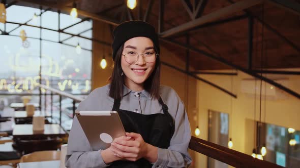 Asian Woman Barista Smiling with Tablet in Her Hand Female Employees Are Taking Orders From Online