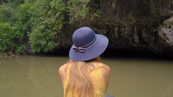 A Young Woman on a Boat Having a River Trip Among Rocks in Ninh Binh a Tourist Destination in