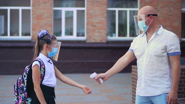 Security Guard, Using Digital Medical Electronic Thermometer, Screens Body Temperature of Schoolgirl